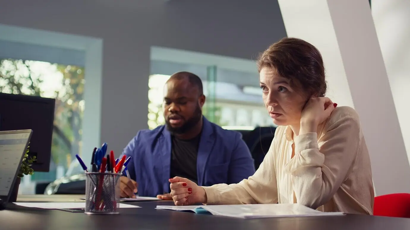 Ein Agent überreicht den Kunden den Kaufvertrag zur Unterschrift, nachdem sie sich für den Kauf entschieden haben.