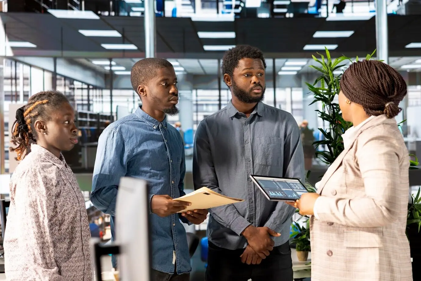 Eine schwarze Managerin überprüft gemeinsam mit ihren Teammitgliedern die Unternehmensstrategie.